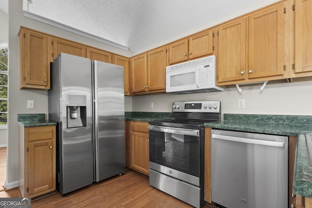 74 Rotunda Ct, Dallas, GA 30157 - kitchen with stainless steel appliances, dark countertops, dark wood-type flooring, and a textured ceiling