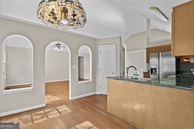 74 Rotunda Ct, Dallas, GA 30157 - kitchen with stainless steel fridge, a sink, a peninsula, wood finished floors, and vaulted ceiling