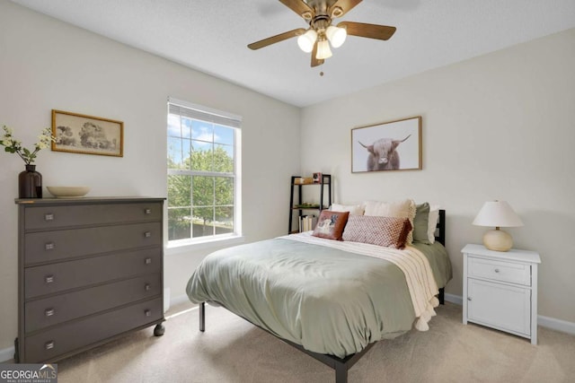 bedroom with light carpet, baseboards, and a ceiling fan