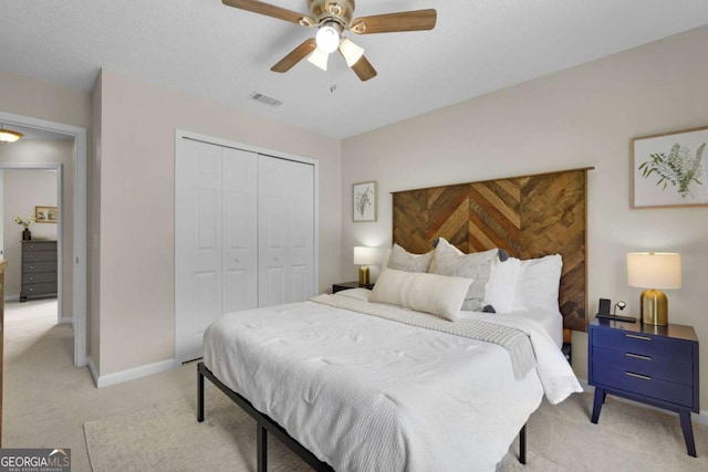 bedroom featuring light carpet, a closet, a ceiling fan, and baseboards