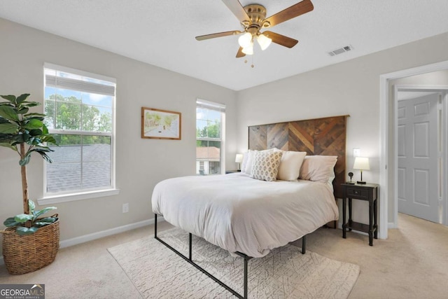 bedroom with light colored carpet, baseboards, and ceiling fan