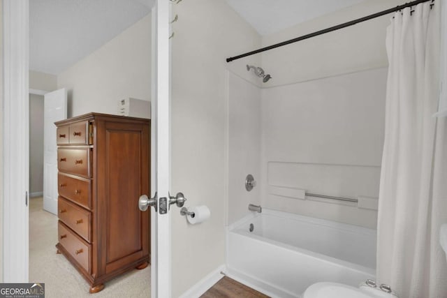 full bathroom with shower / bath combo and baseboards