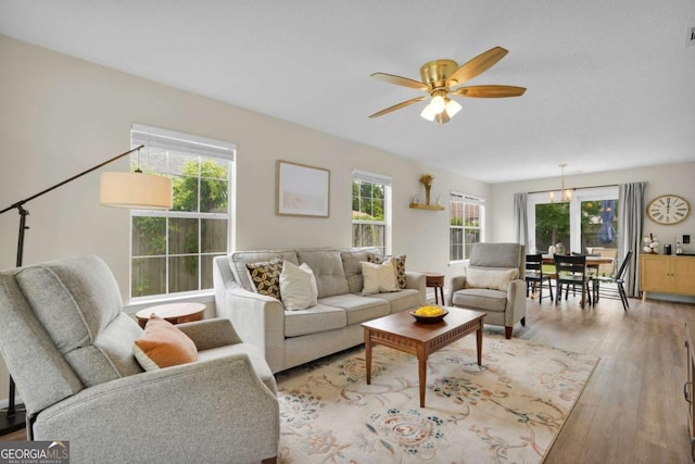 living room featuring healthy amount of natural light, ceiling fan, and wood finished floors