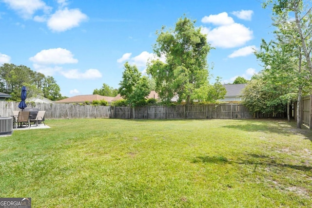 view of yard with central AC unit and a patio