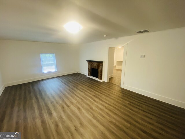 66 Kristys Path Dr, Eastanollee, GA 30538 - unfurnished living room with dark wood-type flooring, a brick fireplace, and baseboards