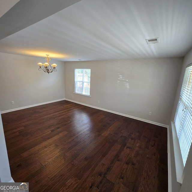 590 Dot Dr, Atlanta, GA 30349 - spare room featuring dark wood-type flooring, a chandelier, and baseboards