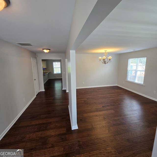 590 Dot Dr, Atlanta, GA 30349 - unfurnished room with healthy amount of natural light, a chandelier, and dark wood-style flooring