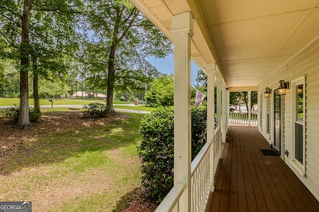 wooden deck with covered porch and a yard