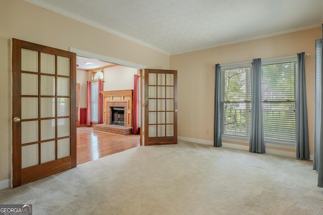 unfurnished living room featuring carpet, french doors, ornamental molding, a brick fireplace, and baseboards
