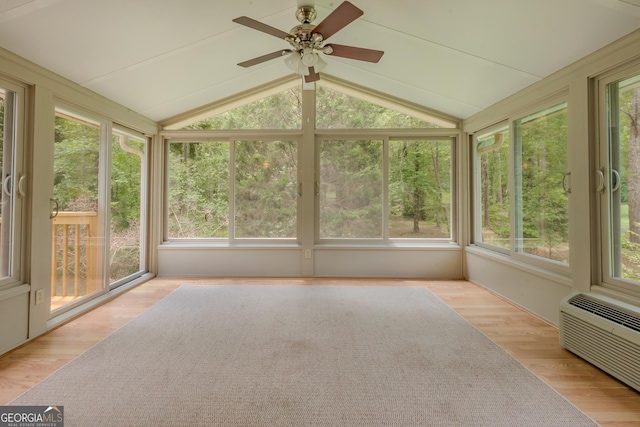 unfurnished sunroom with vaulted ceiling, wood finished floors, and a wall unit AC