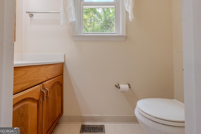 bathroom with toilet, vanity, baseboards, and tile patterned floors