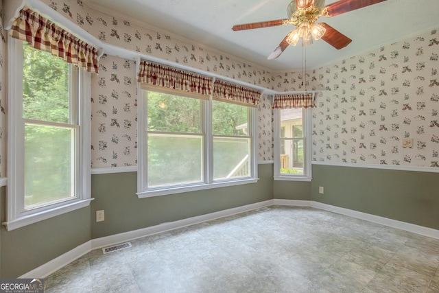 unfurnished room featuring ceiling fan, wallpapered walls, and baseboards
