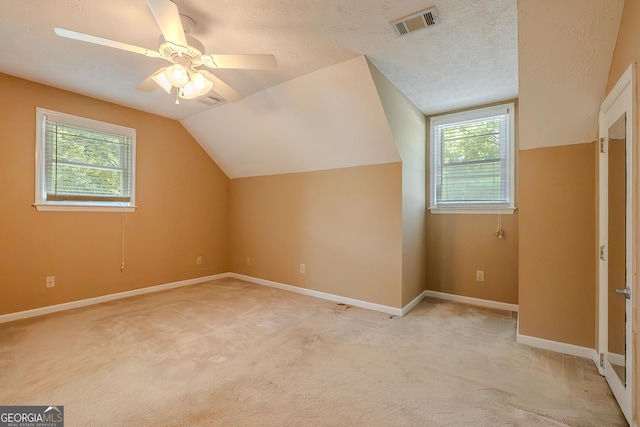 additional living space featuring vaulted ceiling, a ceiling fan, baseboards, and light colored carpet