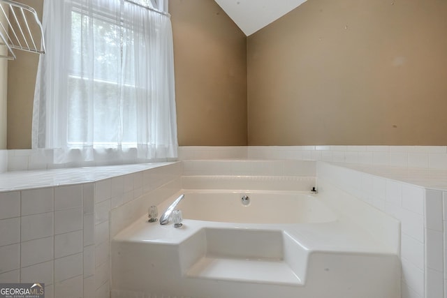 bathroom with a garden tub and vaulted ceiling