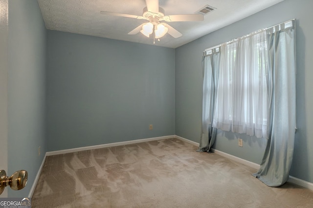 empty room featuring light carpet, baseboards, and ceiling fan