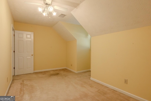 additional living space featuring a ceiling fan, carpet flooring, lofted ceiling, baseboards, and a textured ceiling