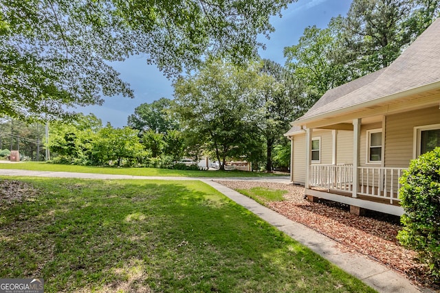 view of grassy yard featuring covered porch