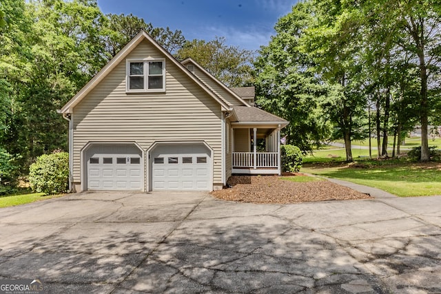 view of front facade featuring driveway, covered porch, and a garage