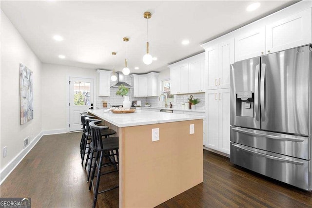 380 Atwood Dr NW, Marietta, GA 30064 - kitchen with stainless steel fridge, wall chimney range hood, dark wood-type flooring, a center island, and a kitchen breakfast bar