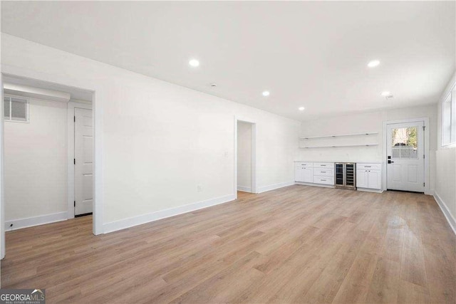 380 Atwood Dr NW, Marietta, GA 30064 - unfurnished living room featuring baseboards, beverage cooler, light wood-style flooring, a bar, and recessed lighting