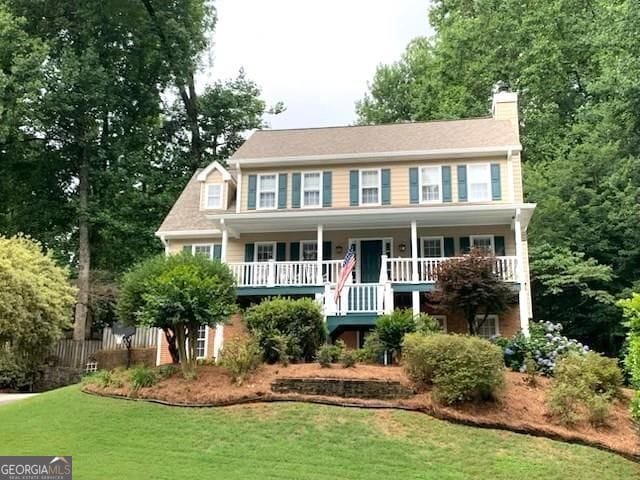 1935 Shrader Ct, Lawrenceville, GA 30044 - colonial inspired home featuring a porch, a chimney, and stairs