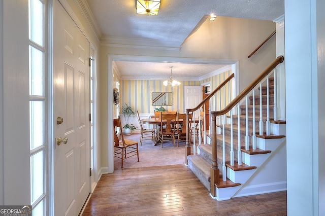 1935 Shrader Ct, Lawrenceville, GA 30044 - entrance foyer featuring stairway, hardwood / wood-style flooring, a chandelier, crown molding, and baseboards