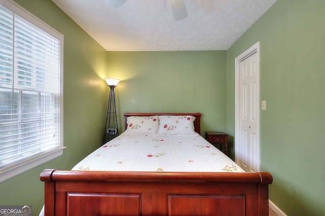 1935 Shrader Ct, Lawrenceville, GA 30044 - bedroom featuring multiple windows, ceiling fan, a textured ceiling, and baseboards