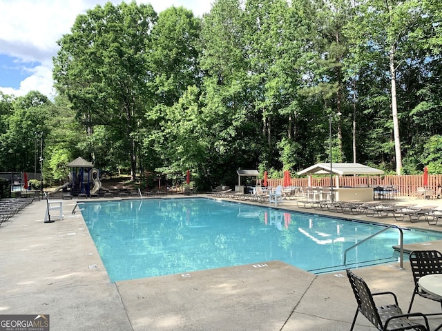 1935 Shrader Ct, Lawrenceville, GA 30044 - community pool featuring a patio and view of scattered trees