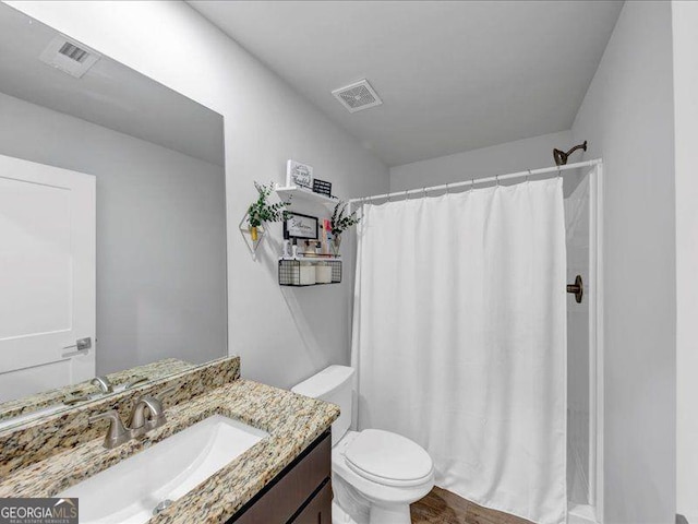 full bath with toilet, vanity, and curtained shower