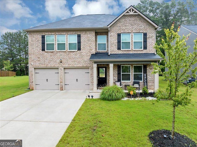 craftsman-style home featuring a garage, covered porch, a front yard, driveway, and brick siding