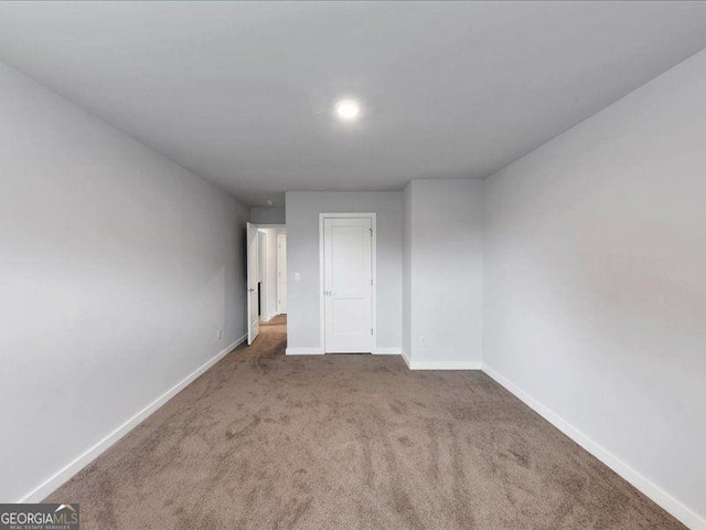 carpeted empty room with baseboards