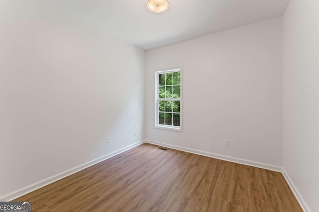 unfurnished room with wood finished floors and baseboards