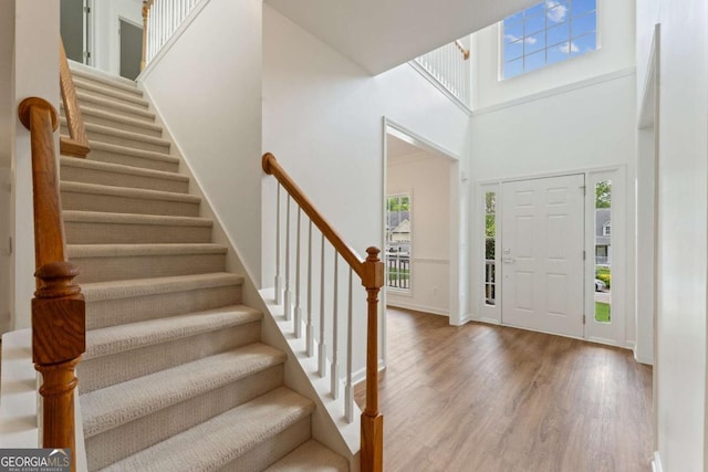 entryway featuring a high ceiling, wood finished floors, and stairway
