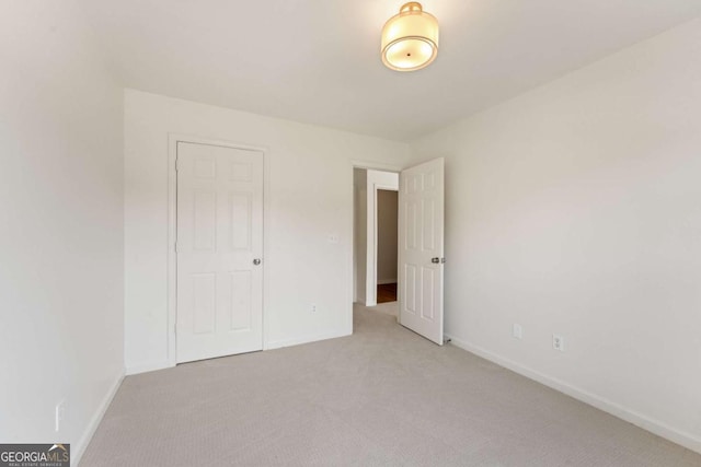 unfurnished bedroom with light carpet and baseboards