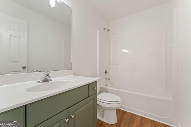 full bath with wood finished floors, toilet, vanity, and  shower combination