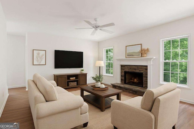 living room featuring a fireplace, baseboards, wood finished floors, and a ceiling fan