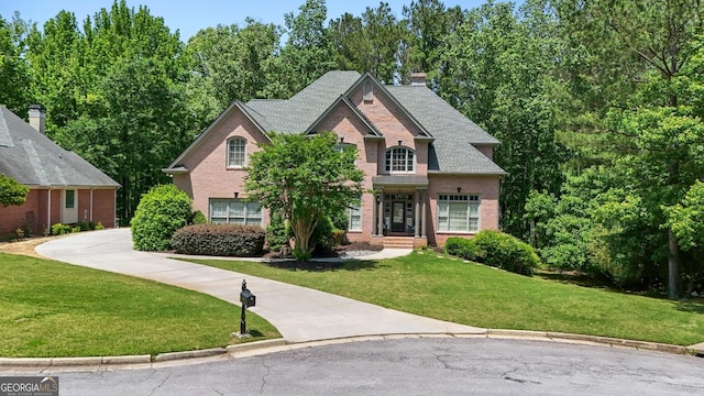 1029 Laurel Grove Cts, Suwanee, GA 30024 - view of front of property featuring brick siding, a front yard, concrete driveway, and a chimney