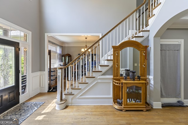 1029 Laurel Grove Cts, Suwanee, GA 30024 - entrance foyer with arched walkways, a towering ceiling, wood finished floors, crown molding, and stairway