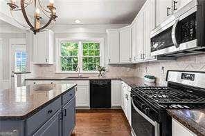 1667 Wehunt Pl SE Unit 11, Smyrna, GA 30082 - kitchen featuring appliances with stainless steel finishes, a chandelier, white cabinetry, and backsplash