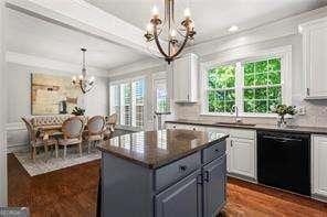 1667 Wehunt Pl SE Unit 11, Smyrna, GA 30082 - kitchen with a chandelier, black dishwasher, white cabinets, dark countertops, and crown molding