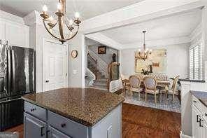 1667 Wehunt Pl SE Unit 11, Smyrna, GA 30082 - kitchen with a chandelier, freestanding refrigerator, a kitchen island, dark stone counters, and white cabinets