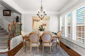 1667 Wehunt Pl SE Unit 11, Smyrna, GA 30082 - dining space featuring a chandelier, wood finished floors, stairway, and crown molding