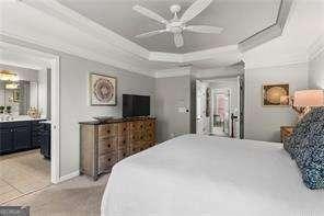 1667 Wehunt Pl SE Unit 11, Smyrna, GA 30082 - bedroom with ornamental molding, a tray ceiling, ensuite bath, and ceiling fan