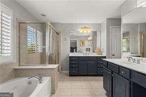 1667 Wehunt Pl SE Unit 11, Smyrna, GA 30082 - full bath featuring a stall shower, a bath, tile patterned flooring, and vanity