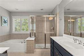 1667 Wehunt Pl SE Unit 11, Smyrna, GA 30082 - bathroom featuring a bath, vanity, a stall shower, and tile patterned flooring