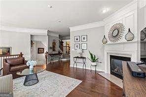 1667 Wehunt Pl SE Unit 11, Smyrna, GA 30082 - living area featuring a glass covered fireplace, wood finished floors, and ornamental molding