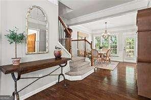 1667 Wehunt Pl SE Unit 11, Smyrna, GA 30082 - hallway featuring wood finished floors, a chandelier, stairway, baseboards, and ornamental molding