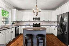 1667 Wehunt Pl SE Unit 11, Smyrna, GA 30082 - kitchen with stainless steel appliances, a sink, a kitchen island, and dark wood finished floors