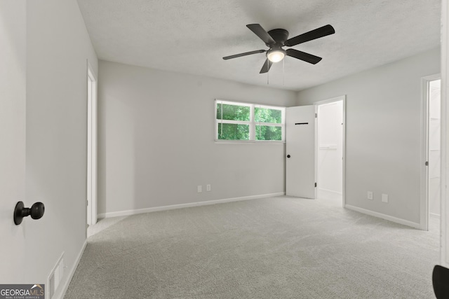 111 Northdale Pl, Lawrenceville, GA 30046 - unfurnished bedroom with carpet flooring, a textured ceiling, baseboards, a ceiling fan, and a walk in closet