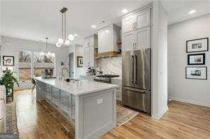 219 Howell Dr SE Unit A, Atlanta, GA 30316 - kitchen featuring freestanding refrigerator, light wood-style flooring, light countertops, gray cabinetry, and a chandelier